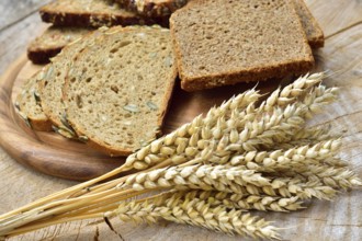 Cereal, wheat and bread on a wooden table. Different types of bread on wood