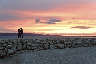 Sunset, couple on a pier, coast near Brela, behind them the island of Brac, Adriatic Sea,