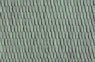 Green roof tiles create a uniform, textured pattern in a repetitive design.Belarus