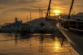 View of Harbor and marina with moored yachts and motorboats at sunset
