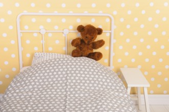 Bedroom with teddy bear sitting on bed