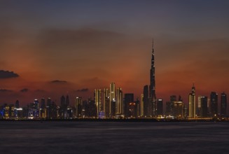 A colorful picture of Downtown Dubai at sunset, with the Burj Khalifa towering the other high rises