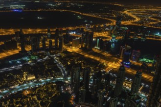 Dubai downtown night scene with city lights. Top view from above