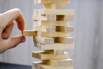 Building from wooden blocks. Wood blocks stack game with Hand on background. Conceptual of Teamwork