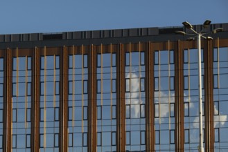 Modern office building exterior with glass facade on clear sky background. Transparent glass wall