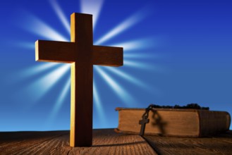 Christian wood cross on blue sky wooden made with Bible and rosary beads