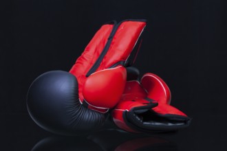 Red and black boxing gloves on black glass table