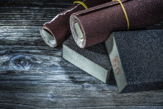Rolled abrasive paper sponges on vintage wooden board