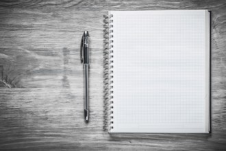 Squared copybook pen on wooden board education concept