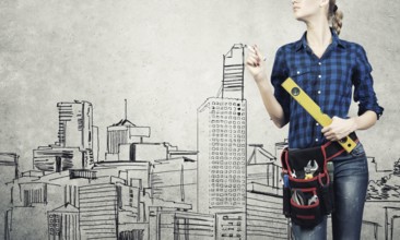 Attractive blond woman builder with ruler in hands draw construction model