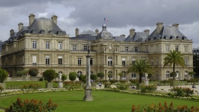 Jardin du Luxembourg with lawns, borders and planters. The Palais du Luxembourg in the background.