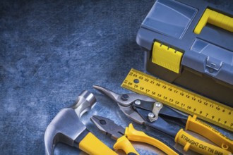 Scratched metallic background with toolbox hammer ruler pliers and tin snips construction concept