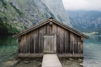 Wooden cottage in beautiful lake in the Alps with misty mood