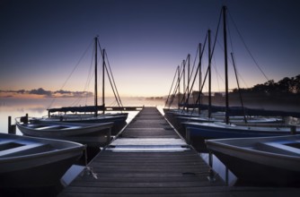 Pier and yacht on lake at sunrise, Netherlands