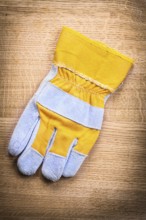 Protective work glove on wooden board construction concept