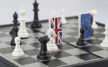 Chess pieces and flags of the European Union and the UK on a chessboard. The concept of the