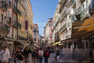 Busy shopping street in Lisbon, Lively city street with many people, surrounded by colourful