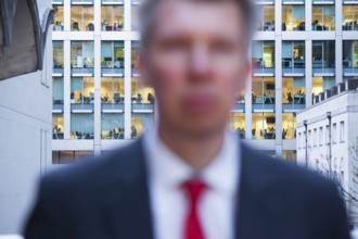 Defocussed businessman looking at the camera at dusk