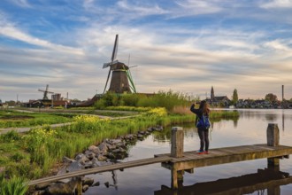 Dutch Windmill at Zaanse Schans Village with woman tourist, Amsterdam Netherlands