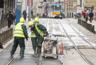 Sofia, Bulgaria - February 27, 2016: Transportation workers are cutting the asphalt at the tram