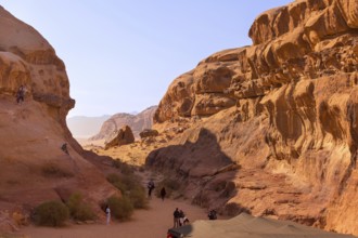 Wadi Rum, Jordan, November 1, 2022: Desert landscape with orange sand and rock formations, people