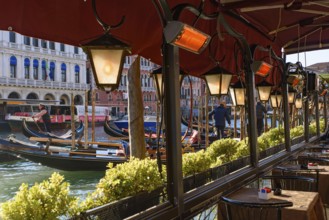 View of the Grand Canal, Rialto Bridge, and gondolas from outdoor restaurant seats, Venice, Italy