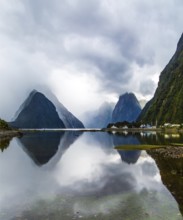 Magic country of fantastic heroes. New Zealand. Storm clouds cover the sky. Mirror-smooth water of