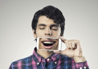 Young man holding smartphone with smile on screen