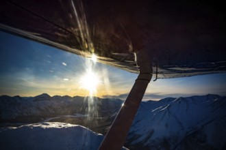 View from an aeroplane of a snow-covered mountain landscape at sunset, Yukon, Canada, Whitehorse
