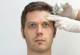 Handsome man is getting injection. Concept of aesthetic beauty. Place for your text
