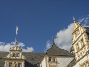 Historic castle with yellow and white façade and towers in front of a blue sky with clouds, Neuhaus