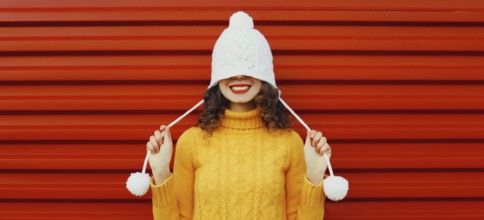 Winter christmas portrait of happy cheerful young woman smiling having fun in yellow sweater, white