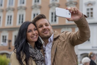 A young couple takes a self-portrait with a mobile phone. Selfies are in. Austria