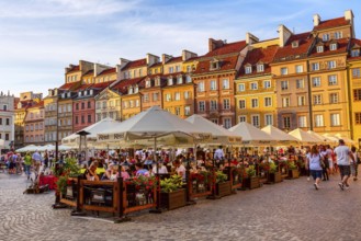 Warsaw, Poland, June 24, 2019: Colorful houses and cafe, restaurant in Market Square in the Old