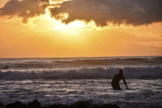 Single surfer at sunset on a calm ocean