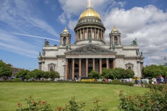 Large cathedral with golden dome, surrounded by greenery and covered by a partly cloudy sky, saint