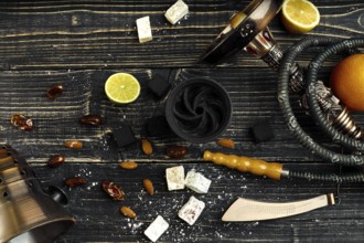 Arabic hookah with a tobacco flavor of a mixture of citruses. Top view of a dark wooden background.