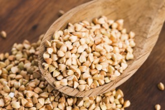 Buckwheat with a spoon on a wooden boards background