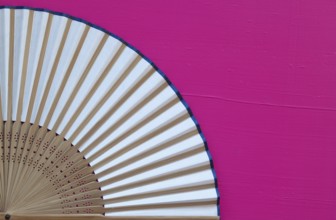 Typical Japanese hand fan made on the wooden pink table