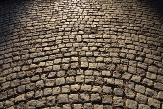 Gloomy old cobblestone pavement. Beautiful stone background
