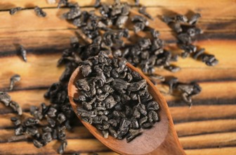 Dry puer tea leaf in wooden spoon on the rustick table