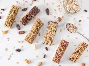 Granola bar with copy space. Set of different granola bars on white marble table. Shallow DOF. Top