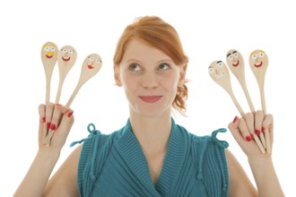 Woman cooking with funny wooden spoons