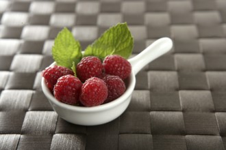 Raspberries with basil leaves, fresh natural dessert