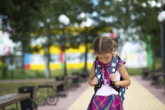 Sad, upset girl near the school with a backpack. Fatigue from classes, resentment, lessons not
