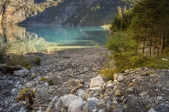 Oeschinensee lake in Switzerland in autumn, landscape photography, crystalic blue water, trees