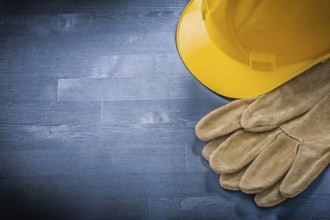 Protective gloves building helmet on wooden board construction concept