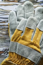 Protective gloves on wooden board top view