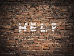 The Word Help Written As Graffiti On A Vintage Red Brick Wall