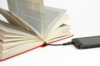 Smartphone connected to a book via USB cable